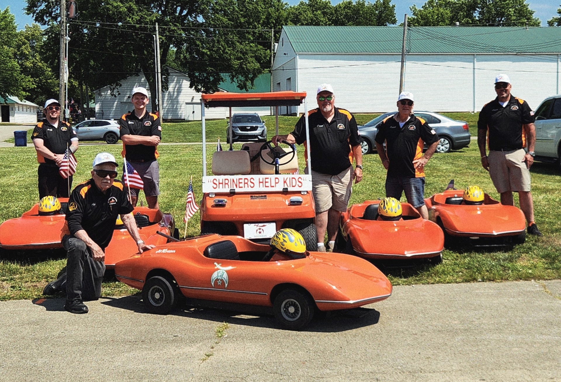 The Al Koran Korvettes with their orange parade cars